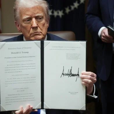 WASHINGTON, DC - MARCH 25: U.S. President Donald Trump holds an executive order he signed during an Ambassador Meeting in the Cabinet Room of the White House on March 25, 2025 in Washington, DC. During the meeting, Trump answered questions from reporters on the news that Jeffrey Goldberg, the editor-in-chief of The Atlantic magazine, was accidentally added to a Signal group chat of top administration officials, where highly sensitive national security information was discussed.   Win McNamee/Getty Images/AFP (Photo by WIN MCNAMEE / GETTY IMAGES NORTH AMERICA / Getty Images via AFP)<!-- NICAID(16003483) -->