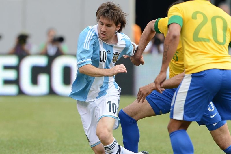 Argentine player Lionel Messi (10) is chased by Brazilian players Hulk (20) and Sandro during the friendly match Argentina against Brazil at the MetLife Stadium in East Rutherford, New Jersey, on June 9, 2012. AFP PHOTO/Emmanuel Dunand<!-- NICAID(8310935) -->