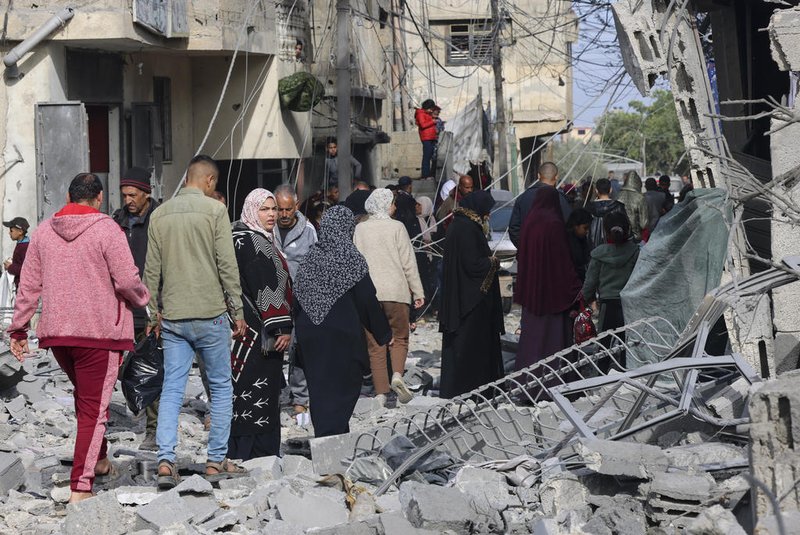 People inspect the damage in the rubble of buildings damaged during Israeli bombardment in Rafah, on the southern Gaza Strip on February 12, 2024, amid ongoing battles between Israel and the militant group Hamas. Israel announced on February 12 the rescue of two hostages in the southern Gaza city of Rafah, where the Hamas-run health ministry said "around 100" Palestinians including children were killed in heavy overnight air strikes. (Photo by SAID KHATIB / AFP)<!-- NICAID(15676569) -->