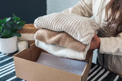 Woman holding Clothes with Donate Box In her room, Donation Concept.Doação, roupas .Foto: shine.graphics / stock.adobe.comFonte: 504330899<!-- NICAID(15762491) -->