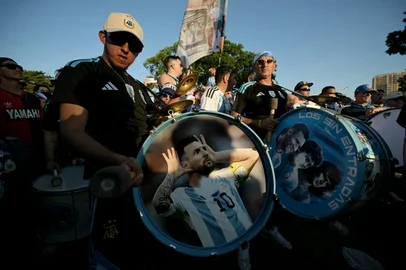 An Argentine supporter hits a bass drum depicting Argentine football player Lionel Messi as he takes part in a "banderazo" flag-waving gathering at Mill Creek Park in Kansas City on June 15, 2026, during the 2026 World Cup football tournament. (Photo by JUAN MABROMATA / AFP)<!-- NICAID(16307547) -->