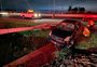 Carro derruba poste e capota em acesso à freeway, em Gravataí