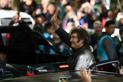 Argentina's President Javier Milei waves to supporters as he leaves after voting during the national midterm legislative election in Buenos Aires on October 26, 2025. Argentines head to the polls for a midterm election that will determine whether President Javier Milei enters the second half of his term bolstered or diminished as economic troubles abound despite unprecedented US aid. (Photo by Luis ROBAYO / AFP)<!-- NICAID(16154151) -->