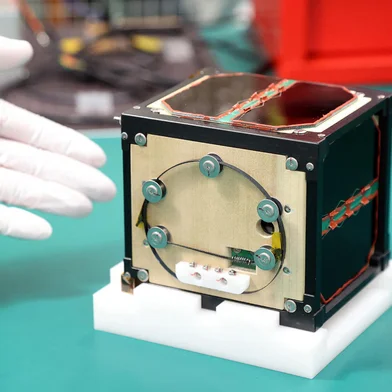 (FILES) This file photo taken on May 28, 2024 shows the world's first satellite made from wood, named LignoSat, developed by scientists at Kyoto University and logging company Sumitomo Forestry, during a press conference in Kyoto. The world's first wooden satellite has blasted off on a SpaceX rocket, its Japanese developers said on November 5, 2024, part of an resupply mission to the International Space Station. (Photo by JIJI PRESS / AFP) / Japan OUT<!-- NICAID(15906955) -->