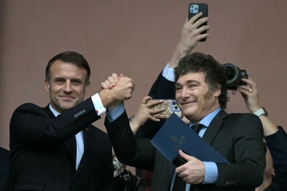 France's President Emmanuel Macron (L) and Argentina's President Javier Milei hold hands on the balcony of the Casa Rosada government palace after a meeting in Buenos Aires on November 17, 2024. (Photo by JUAN MABROMATA / AFP)<!-- NICAID(15915428) -->