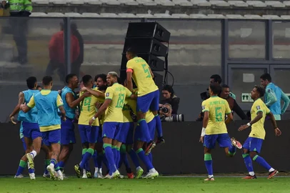 CRIS BOURONCLE / AFP Brazilian players celebrate a goal scored by teammate defender Marquinhos (covered) during the 2026 FIFA World Cup South American qualifiers football match between Peru and Brazil, at the Nacional stadium in Lima, on September 12, 2023. (Photo by CRIS BOURONCLE / AFP)<!-- NICAID(15538887) -->