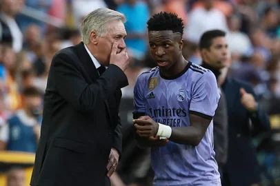 Real Madrid's Brazilian forward Vinicius Junior listens to Real Madrid's Italian coach Carlo Ancelotti (L) during the Spanish league football match between Valencia CF and Real Madrid CF at the Mestalla stadium in Valencia on May 21, 2023. (Photo by JOSE JORDAN / AFP)<!-- NICAID(15440539) -->