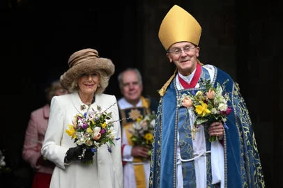 Britain's Queen Camilla leaves the Royal Maundy Service with Bishop of Worcester Cathedral, The Right Reverend Dr John Inge (R) where she distributed the Maundy money to 75 men and 75 women, mirroring the age of the monarch, in Worcester Cathedral, western England on March 28, 2024, to thank them for their outstanding Christian service and for making a difference to the lives of people in their local communities. Maundy Thursday is the Christian holy day falling on the Thursday before Easter. The monarch commemorates Maundy by offering 'alms' to senior citizens. Each recipient receives two purses, one red and one white. (Photo by JUSTIN TALLIS / POOL / AFP)<!-- NICAID(15719440) -->