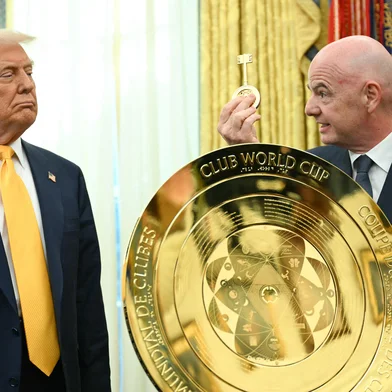 US President Donald Trump watches as FIFA president (Fédération Internationale de Football Association) Gianni Infantino presents him with the key to unlock the new FIFA Club World Cup trophy in the Oval office of the White House, in Washington, DC, on March 7, 2025. (Photo by Jim WATSON / AFP)<!-- NICAID(15991278) -->