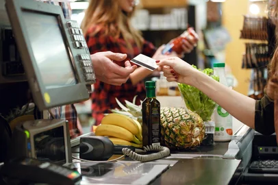 Cropped picture of young man gives credit card to cashierAdobe Stock - Foto recortada de jovem dá cartão de crédito para caixa no espaço de trabalho do supermercado.Cropped picture of young man gives credit card to cashier lady at workspace in supermarket.Fonte: 144121670<!-- NICAID(15986276) -->