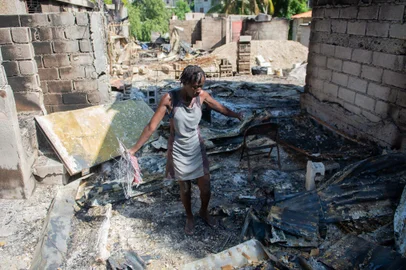 A woman looks through the burned remains of her home the Solino district in Port-au-Prince on November 16, 2024, a day after gangs took over the area. On November 13, 2024, the Solino neighborhood fell under the control of the "Viv Ansanm" ("Live Together") gang alliance, which formed in February and worked to oust former Haitian Prime Minister Ariel Henry, who resigned from his post in April. (Photo by Clarens SIFFROY / AFP)Editoria: WARLocal: Port-au-PrinceIndexador: CLARENS SIFFROYSecao: civil unrestFonte: AFPFotógrafo: STR<!-- NICAID(15950736) -->