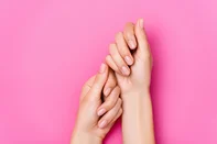 top view of female hands with pastel nail varnish on fingernails on pink backgroundFonte: 404512832<!-- NICAID(16164433) -->