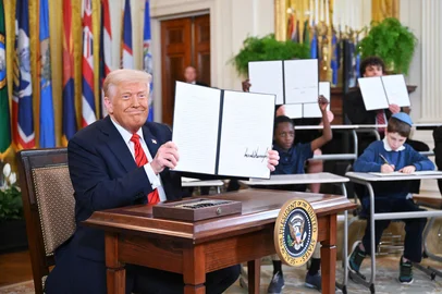 US President Donald Trump holds up an executive order after signing it in the East Room of the White house in Washington, DC, March 20, 2025. US President Donald Trump will sign an order March 20, 2025 to start dismantling the Department of Education, fulfilling an election campaign pledge and a long-held dream of American conservatives. By law, the Education Department -- created in 1979 -- cannot be shuttered without the approval of Congress, and Republicans do not have the votes to push that through. (Photo by Mandel NGAN / AFP)Editoria: EDULocal: WashingtonIndexador: MANDEL NGANSecao: governmentFonte: AFPFotógrafo: STF<!-- NICAID(16000473) -->