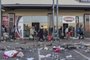 Looters take away few items they left to grab in a vandalised mall in Vosloorus, on July 14, 2021. - The raging unrest first erupted last Friday after former president Jacob Zuma started serving a 15-month term for contempt, having snubbed a probe into the corruption that stained his nine years in power. "The total number of people who have lost their lives since the beginning of these protests ... has risen to 72," the police said in a statement late on July 13. (Photo by MARCO LONGARI / AFP)<!-- NICAID(14834152) -->