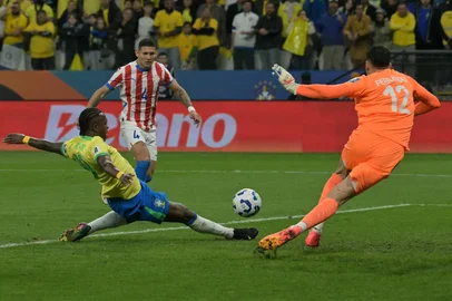 Brazil's forward #10 Vinicius Jr fight for the ball past Paraguay's defender #04 Juan Caceres and goalkeeper #12 Roberto Fernandez during the 2026 FIFA World Cup South American qualifiers football match between Brazil and Paraguay at the Neo Quimica Arena in Sao Paulo, Brazil, on June 10, 2025. (Photo by NELSON ALMEIDA / AFP)Editoria: SPOLocal: Sao PauloIndexador: NELSON ALMEIDASecao: soccerFonte: AFPFotógrafo: STF<!-- NICAID(16056995) -->