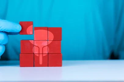 Timely diagnosis of prostate cancer. Routine medical checkup concept. The doctor organizes and arranges the wooden cubes with the icon of the bladder and prostate.Fonte: 762846661<!-- NICAID(15816212) -->