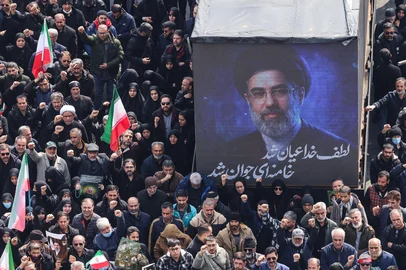A screen displays a portrait of Iran's new supreme leader Mojtaba Khamenei during the funerals of Iran's Revolutionary Guards Corps (IRGC) commanders, army commanders and others killed in the early days of the United States and Israeli strikes on Iran, at Enghelab Square in Tehran on March 11, 2026. Washington launched strikes with Israel on Iran on February 28, sparking retaliatory strikes by Tehran against Israel and US bases across the Gulf region. (Photo by ATTA KENARE / AFP) / Attention editors: Photo taken with approval from the Ministry of Culture and Islamic Guidance (Ershad) --AFP covers the war in the Middle East through its extensive regional network, including bureaus in Tehran, Jerusalem, and several neighboring countries. Since the start of the conflict, journalists have been working under increasingly restrictive conditions. Authorities in several countries have limited reporters' movements, photo and live video coverage from sensitive locations. Some governments and armed groups have banned images of missile or drone strikes and other security-related sites. / <!-- NICAID(16242958) -->