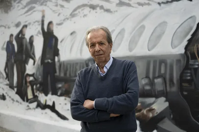 (FILES) Daniel Fernandez, one of the sixteen survivors of the plane crash of Uruguayan Air Force Flight 571 in the Andes Mountains on October 13, 1972, poses in front of a mural made by Graff Express depicting the accident in Montevideo, on November 15, 2023. Daniel Fernandez, 79, died on May 8, 2025, in Montevideo. (Photo by Eitan ABRAMOVICH / AFP)<!-- NICAID(16033407) -->
