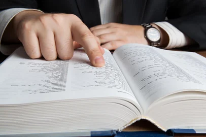 man looking in the large dictionary close upFonte: 70731415<!-- NICAID(14810918) -->