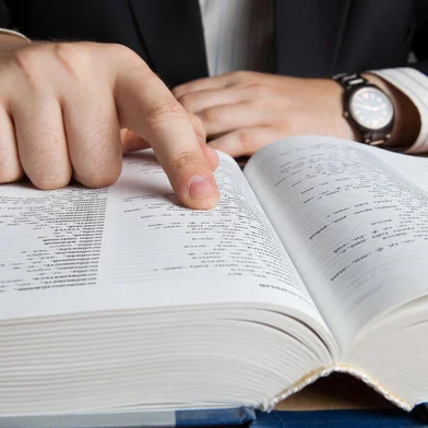 man looking in the large dictionary close upFonte: 70731415<!-- NICAID(14810918) -->
