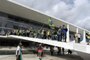 Supporters of Brazilian former President Jair Bolsonaro invade Planalto Presidential Palace in Brasilia on January 8, 2023. - Hundreds of supporters of Brazil's far-right ex-president Jair Bolsonaro broke through police barricades and stormed into Congress, the presidential palace and the Supreme Court Sunday, in a dramatic protest against President Luiz Inacio Lula da Silva's inauguration last week. (Photo by Ton MOLINA / AFP)<!-- NICAID(15316452) -->