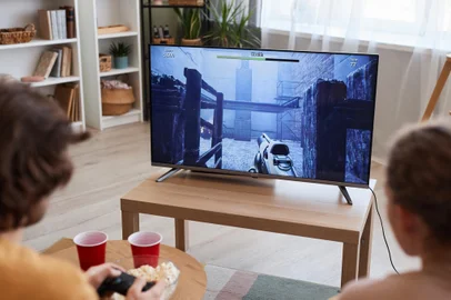 Couple playing video games on TVSedentarismo, videogame, ma alimentação. Foto: Seventyfour / stock.adobe.comFonte: 618610027<!-- NICAID(15856765) -->