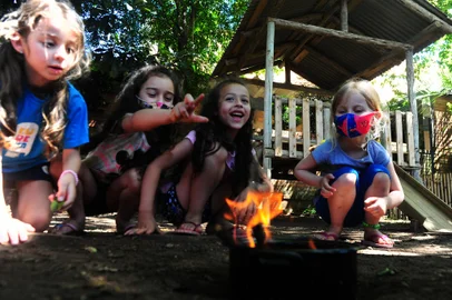 CAXIAS DO SUL, RS, BRASIL, 04/11/2021. Escola Infantil EUREKA. Case da reportagem do Almanaque sobre “Infância e contato com a natureza”. O diferencial dessa escola é justamente a abordagem de oferecer às crianças maior tempo em contato com a terra, com as plantas, chuva, insetos, pássaros, no que eles chamam de “desemparedamento” da infância. Na foto, alunos do Pré II, aprendendo sobre FOGO. (Porthus Junior/Agência RBS)Indexador:                                 <!-- NICAID(14932787) -->