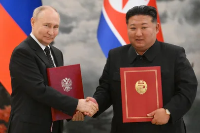 Russian President Vladimir Putin visitsIn this pool photograph distributed by the Russian state agency Sputnik, Russia's President Vladimir Putin (L) shakes hands with North Korea's leader Kim Jong Un during a meeting in Pyongyang on June 19, 2024. Putin enjoyed a red carpet welcome, a military ceremony and an embrace from North Korea's Kim Jong Un during a state visit to Pyongyang where they both pledged to forge closer ties. (Photo by Gavriil GRIGOROV / POOL / AFP) / -- Editor's note : this image is distributed by the Russian state owned agency Sputnik --Editoria: POLLocal: PyongyangIndexador: KRISTINA KORMILITSYNASecao: politics (general)Fonte: POOLFotógrafo: STR<!-- NICAID(15792575) -->