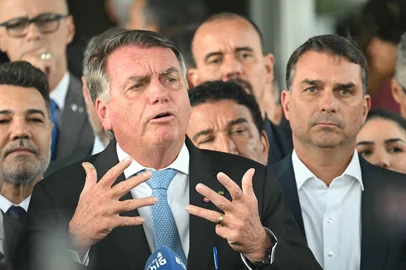 Former Brazil's President Jair Bolsonaro speaks to the media next to his son Senator Flavio Bolsonaro (R), after leaving the Senate building in Brasilia on March 26, 2025. Brazil's Supreme Court on March 26, 2025, ordered far-right ex-president Jair Bolsonaro to stand trial on charges of plotting a coup after failing to win re-election in 2022. (Photo by EVARISTO SA / AFP)Editoria: CLJLocal: BrasíliaIndexador: EVARISTO SASecao: justice and rightsFonte: AFPFotógrafo: Handout<!-- NICAID(16003874) -->
