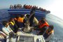 In this handout picture released by the Italian navy on April 10, 2014 immigrants stand on a boat during a rescue operation off the coast of Sicily on October 30, 2013. The Italian navy said on April 10, 2014 it had rescued nearly 20,000 migrants since launching a Mediterranean operation following two deadly shipwrecks in October 2013.  Navy chief Giuseppe De Giorgi said the rate of arrivals was increasing "and we are following six boats today".= RESTRICTED TO EDITORIAL USE - MANDATORY CREDIT "AFP PHOTO / MARINA MILITARE" - NO MARKETING NO ADVERTISING CAMPAIGNS - DISTRIBUTED AS A SERVICE TO CLIENTS =