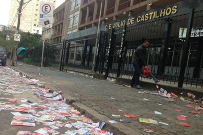 Santinhos espalhados pelo chão em frente ao colégio Julio de Castilhos, em Porto Alegre
