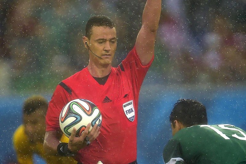 491712519Colombian referee Wilmar Roldan gives a yellow card during a Group A football match between Mexico and Cameroon at the Dunas Arena in Natal during the 2014 FIFA World Cup on June 13, 2014. AFP PHOTO / PIERRE-PHILIPPE MARCOUEditoria: SPOLocal: NatalIndexador: PIERRE-PHILIPPE MARCOUSecao: SoccerFonte: AFPFotógrafo: STF