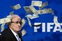 -FIFA president Sepp Blatter looks on with fake dollars note flying around him thrown by a protester during a press conference at the football's world body headquarter's on July 20, 2015 in Zurich. FIFA said today that a special election will be held on February 26 to replace president Sepp Blatter.   AFP PHOTO / FABRICE COFFRINIEditoria: SPOLocal: ZurichIndexador: FABRICE COFFRINISecao: SoccerFonte: AFPFotógrafo: STR