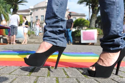 Blumenau-sc-Brasil, Ato público contra homofobia no jardim do teatro Carlos Gomes- Rodrigo Kalbusch de salto alto passa em frente a bandeira simbolo gay
