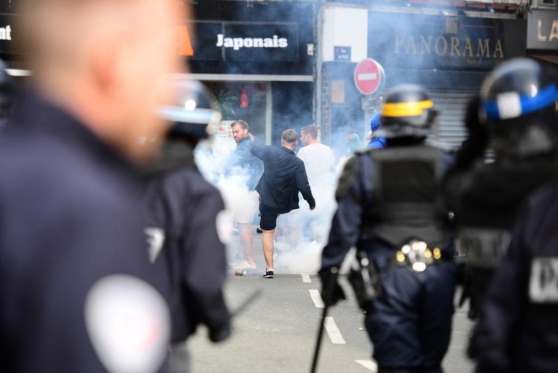 French policemen fire tear gas to disperse supporters gathering outside a bar in Lille, northern France, on June 15, 2016, on the sideline of the Euro 2016 European football championships.  / AFP PHOTO / LEON NEAL