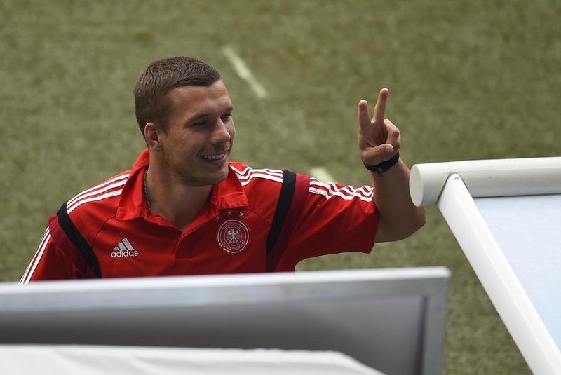 Germanys forward Lukas Podolski does the victory sign before the semi-final football match between Brazil and Germany at The Mineirao Stadium in Belo Horizonte during the 2014 FIFA World Cup on July 8, 2014.  AFP PHOTO / ODD ANDERSEN