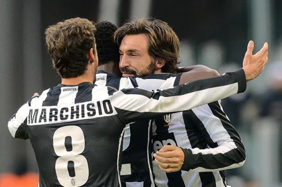 Juventus' midfielder Andrea Pirlo celebrates with his teammates after scoring against Atalanta during their Italian Serie A football match on December 16, 2012 at Turin's Juventus stadium.  AFP PHOTO / ANDREAS SOLARO