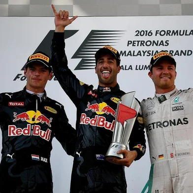 Second-placed Red Bull Racing's Belgian-Dutch driver Max Verstappen (L), champion Red Bull Racing's Australian driver Daniel Ricciardo (C) and third-placed Mercedes AMG Petronas F1 Team's German driver Nico Rosberg (R) celebrate on the podium during the Formula One Malaysian Grand Prix in Sepang on October 2, 2016. / AFP PHOTO / MANAN VATSYAYANA