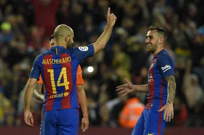 Barcelona's Argentinian defender Javier Mascherano (L) celebrates with Barcelona's forward Paco Alcacer (R) after scoring a penalty goal during the Spanish league football match FC Barcelona vs CA Osasuna at the Camp Nou stadium in Barcelona on April 26, 2017. / AFP PHOTO / LLUIS GENE