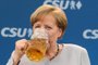 German Chancellor Angela Merkel takes a sip of beer after delivering a speech during a joint campaigning event of the Christian Democratic Union (CDU) and the Christion Social Union (CSU) in Munich, southern Germany, on May 27, 2017.  / AFP PHOTO / dpa / Matthias Balk / Germany OUT / ALTERNATIVE CROP
