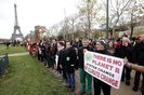 A demonstrator holds a banner reading "There is no planet B, system change, not climate" during a rally called by several Non Governmental Organisations (NGO) to form a human chain on the Champs de Mars near the Eiffel Tower in Paris on December 12, 2015 on the sidelines of the COP21, the UN conference on global warming.French hosts submit the final version of a global climate-saving pact to negotiators at UN Conference on december 12. The goal is for ministers to approve the agreement by the end of the day but that could be extended one more day. / AFP / FRANCOIS GUILLOT