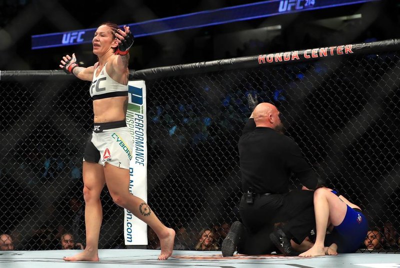 Cris Cyborg nocauteia Tonya Evinger e conquista cinturão do peso pena feminino no UFC 214