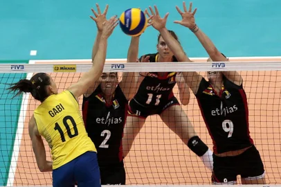 Brazils Gabi (L) spikes the ball against Belgiums Biebauw, Vandesteene and Aelbrecht (R)  during  a World Grand Prix 2015 volleyball match, in Sao Paulo, Brazil on July 10 2015. AFP PHOTO / Miguel SCHINCARIOL