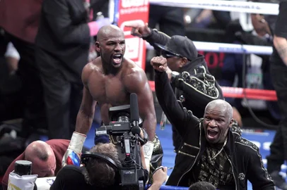 Boxing: Mayweather v McGregorBoxer Floyd Mayweather Jr. and his father Floyd Mayweather Sr. celebrate his 10th round TKO victory over mixed martial arts star Conor McGregor at the T-Mobile Arena in Las Vegas, Nevada. Undefeated welterweight boxing world champion Mayweather overcame a spirited start from a brave but outclassed McGregor, dominating from the fourth round onwards. The end came with a tired McGregor doubled over on the ropes as Mayweather landed two hard left hooks. / AFP PHOTO / John GurzinskiEditoria: SPOLocal: Las VegasIndexador: JOHN GURZINSKISecao: boxingFonte: AFPFotógrafo: STR