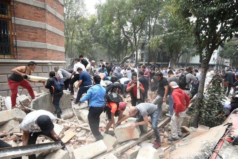People remove debris of a damaged building after a real quake rattled Mexico City on September 19, 2017 while an earthquake drill was being held in the capital.
A powerful earthquake shook Mexico City on Tuesday, causing panic among the megalopolis 20 million inhabitants on the 32nd anniversary of a devastating 1985 quake. The US Geological Survey put the quakes magnitude at 7.1 while Mexicos Seismological Institute said it measured 6.8 on its scale. The institute said the quakes epicenter was seven kilometers west of Chiautla de Tapia, in the neighboring state of Puebla.
 / AFP PHOTO / Alfredo ESTRELLA