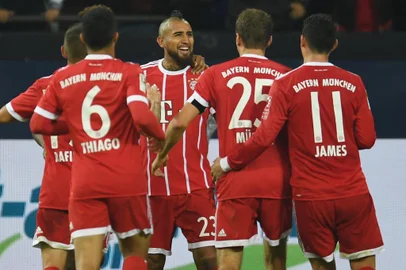 Bayern Munichs Chilean midfielder Arturo Vidal and his teammates celebrate during the German First division Bundesliga football match between FC Schalke 04 and FC Bayern Munich in Gelsenkirchen, western Germany, on September 19, 2017. / AFP PHOTO / PATRIK STOLLARZ / RESTRICTIONS: DURING MATCH TIME: DFL RULES TO LIMIT THE ONLINE USAGE TO 15 PICTURES PER MATCH AND FORBID IMAGE SEQUENCES TO SIMULATE VIDEO. == RESTRICTED TO EDITORIAL USE == FOR FURTHER QUERIES PLEASE CONTACT DFL DIRECTLY AT + 49 69 650050
