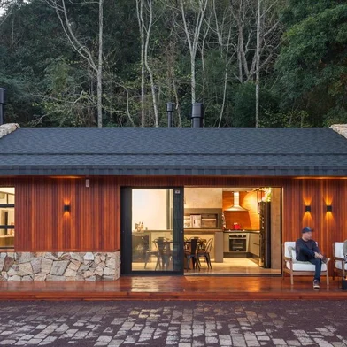 Projeto do escritório Cadi Arquitetura. Chalé, pedra, madeira, ferro, tijolo, lago