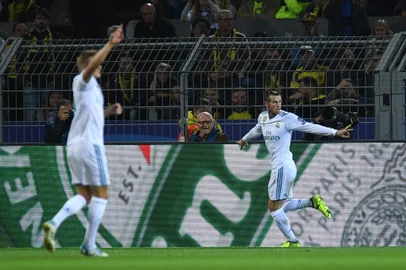Real Madrids forward from Wales Gareth Bale (R) celebrates scoring the opening goal with his teammates during the UEFA Champions League Group H football match BVB Borussia Dortmund v Real Madrid in Dortmund, western Germany on September 26, 2017. / AFP PHOTO / Patrik STOLLARZ
