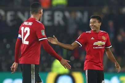 Manchester Uniteds English defender Chris Smalling (L) and Manchester Uniteds English midfielder Jesse Lingard applauds the fans following the English League Cup fourth round football match between Swansea City and Manchester United at The Liberty Stadium in Swansea, south Wales on October 24, 2017. / AFP PHOTO / Geoff CADDICK / RESTRICTED TO EDITORIAL USE. No use with unauthorized audio, video, data, fixture lists, club/league logos or live services. Online in-match use limited to 75 images, no video emulation. No use in betting, games or single club/league/player publications.  / 