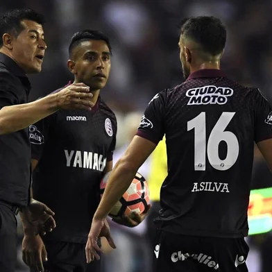 The coach of Argentina's Lanus, Jorge Almiron (L), speask to players during their Copa Libertadores semifinal second leg football match against Argentina's River Plate in Lanus, on the outskirts of Buenos Aires, on October 31, 2017. / AFP PHOTO / Juan MABROMATA